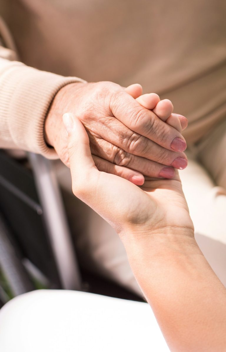 Carer holding a client's hand