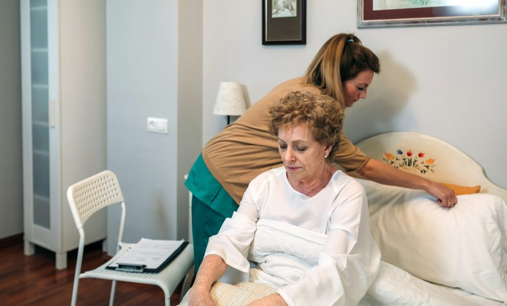 Carer adjusting a pillow for an elderly client