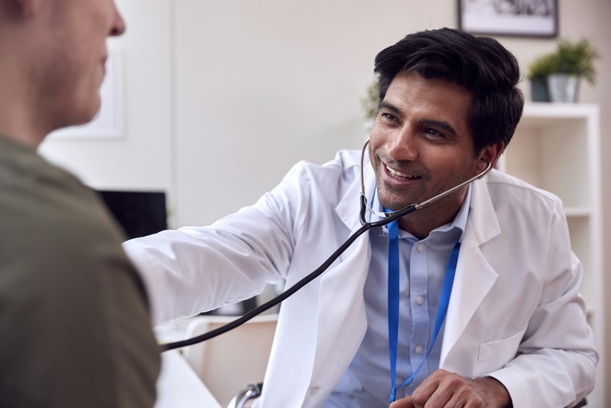 Doctor checking a young man's chest with a stethoscope